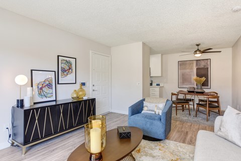 a living room with a couch and a chair and a dining room table